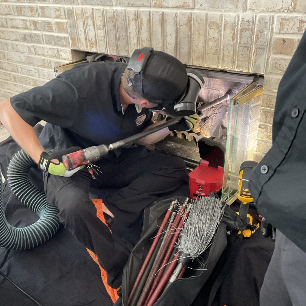 10 Easy Orlando Chimney Sweep Tips by Always Home Sweep 8 A professional Orlando chimney sweep technician uses specialized rotary power tools to clean the interior fireplace flue, with specialized brushes and a vacuum hose nearby on a drop cloth.