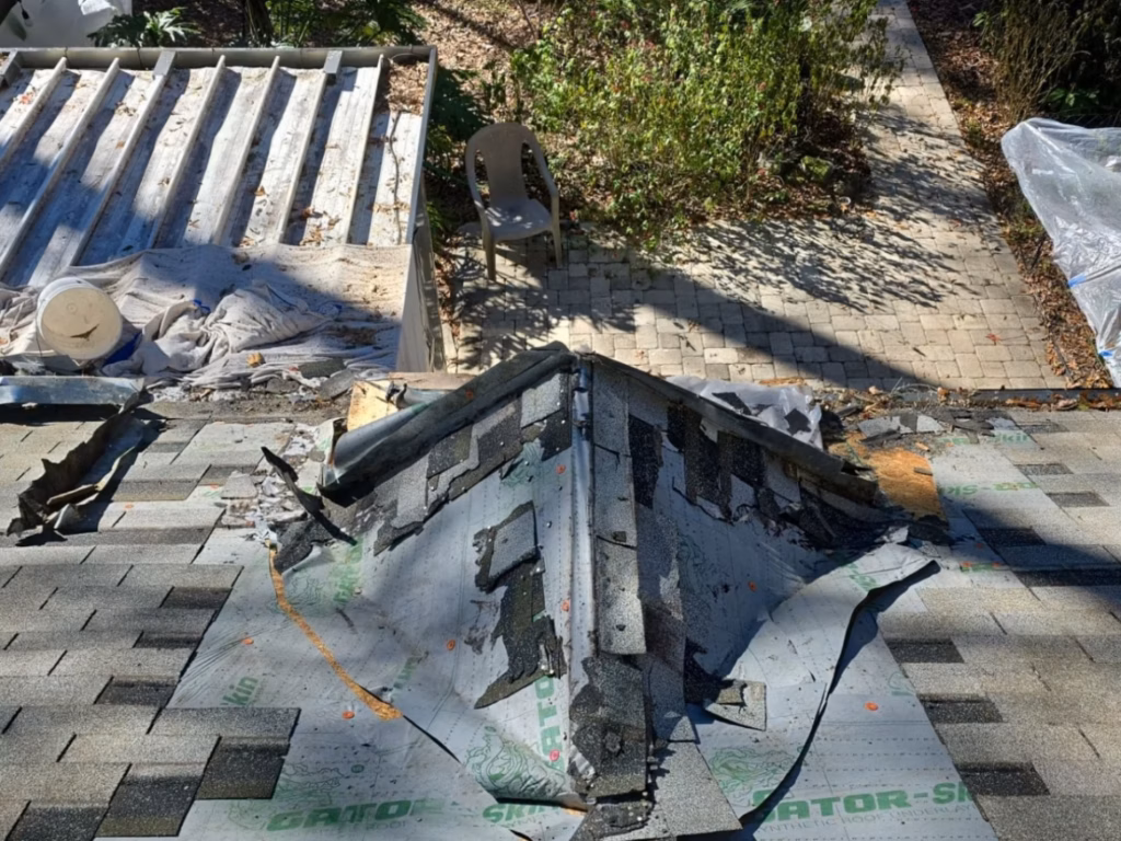 Shingles removed around a chimney cricket and saddle during a leaky chimney repair in Gainesville, FL.