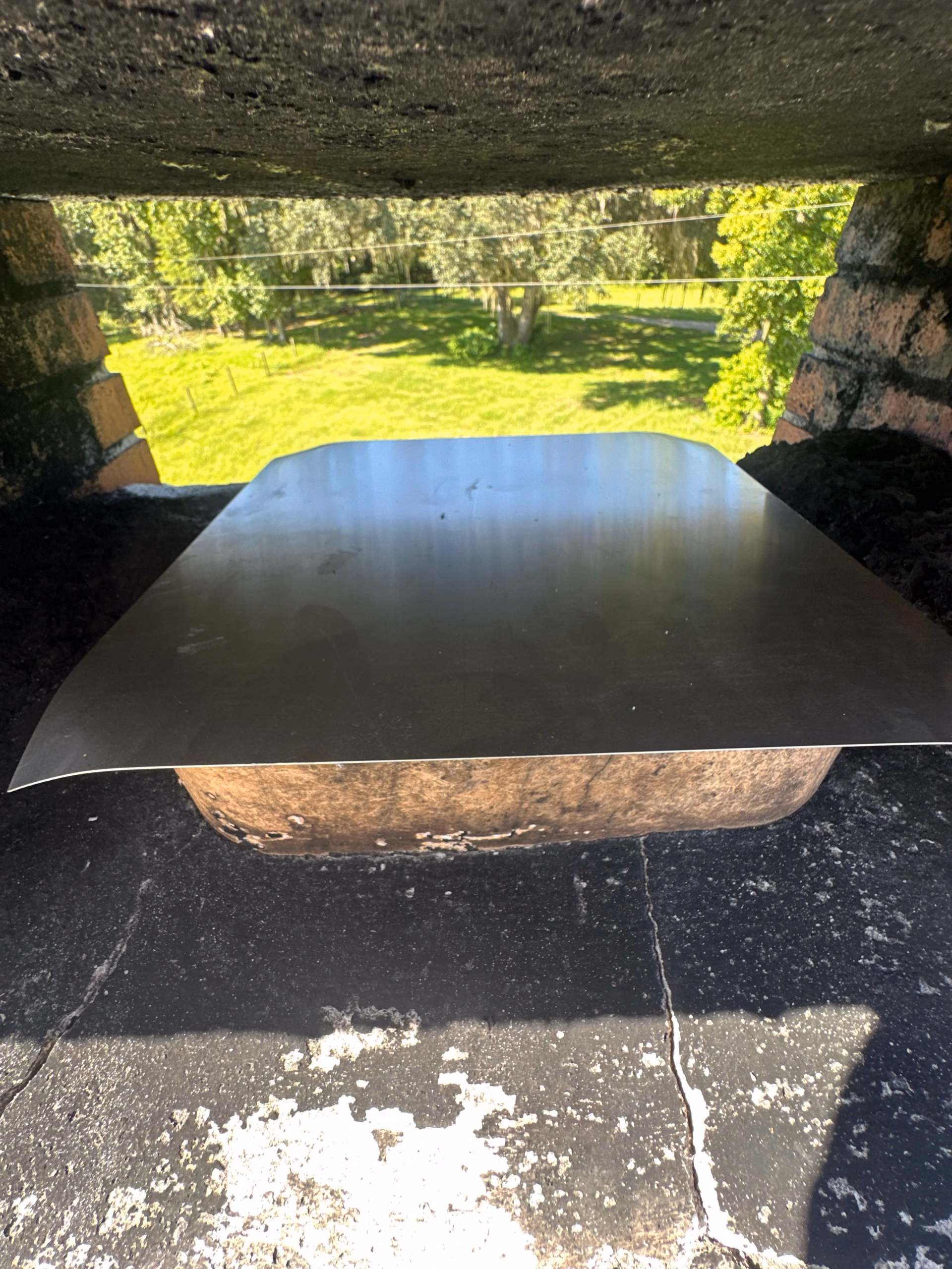 technician inspecting a chimney damper plate for rust and warping