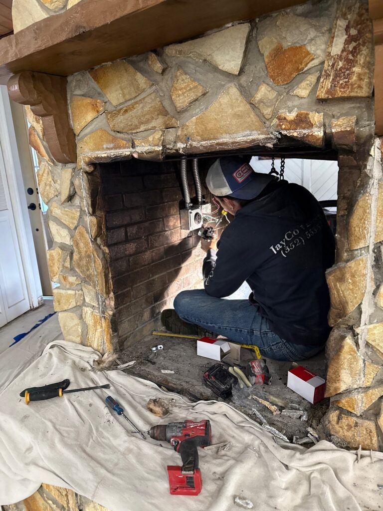 homeowner adjusting controls on a wall-mounted electric fireplace in Dunnellon FL