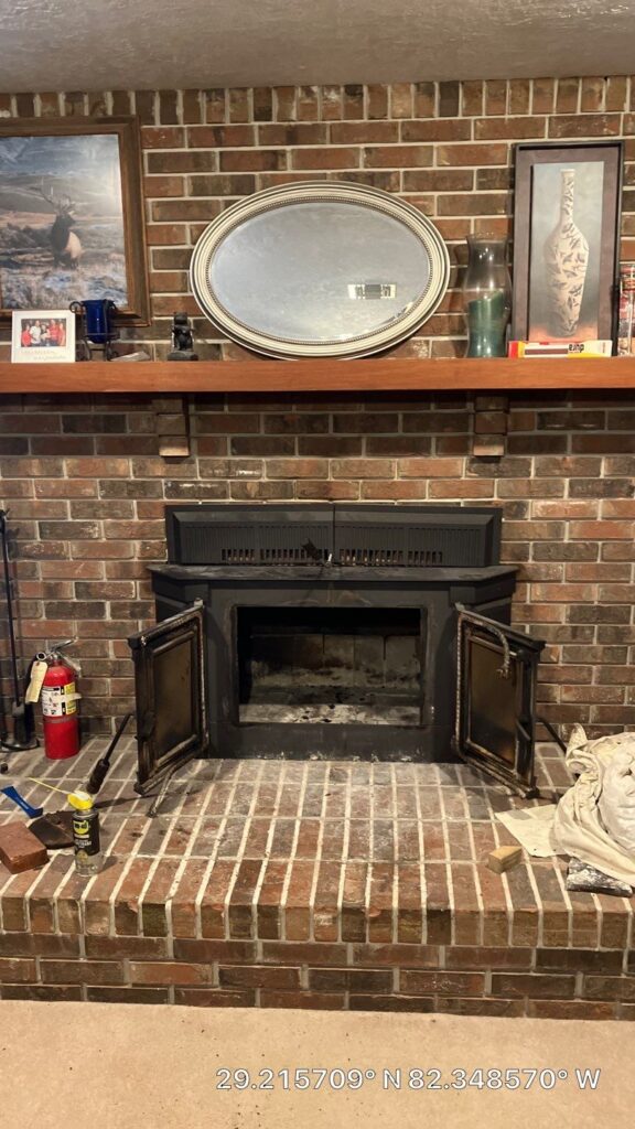 homeowner cleaning the flame lens on an electric fireplace insert in an Ocala den