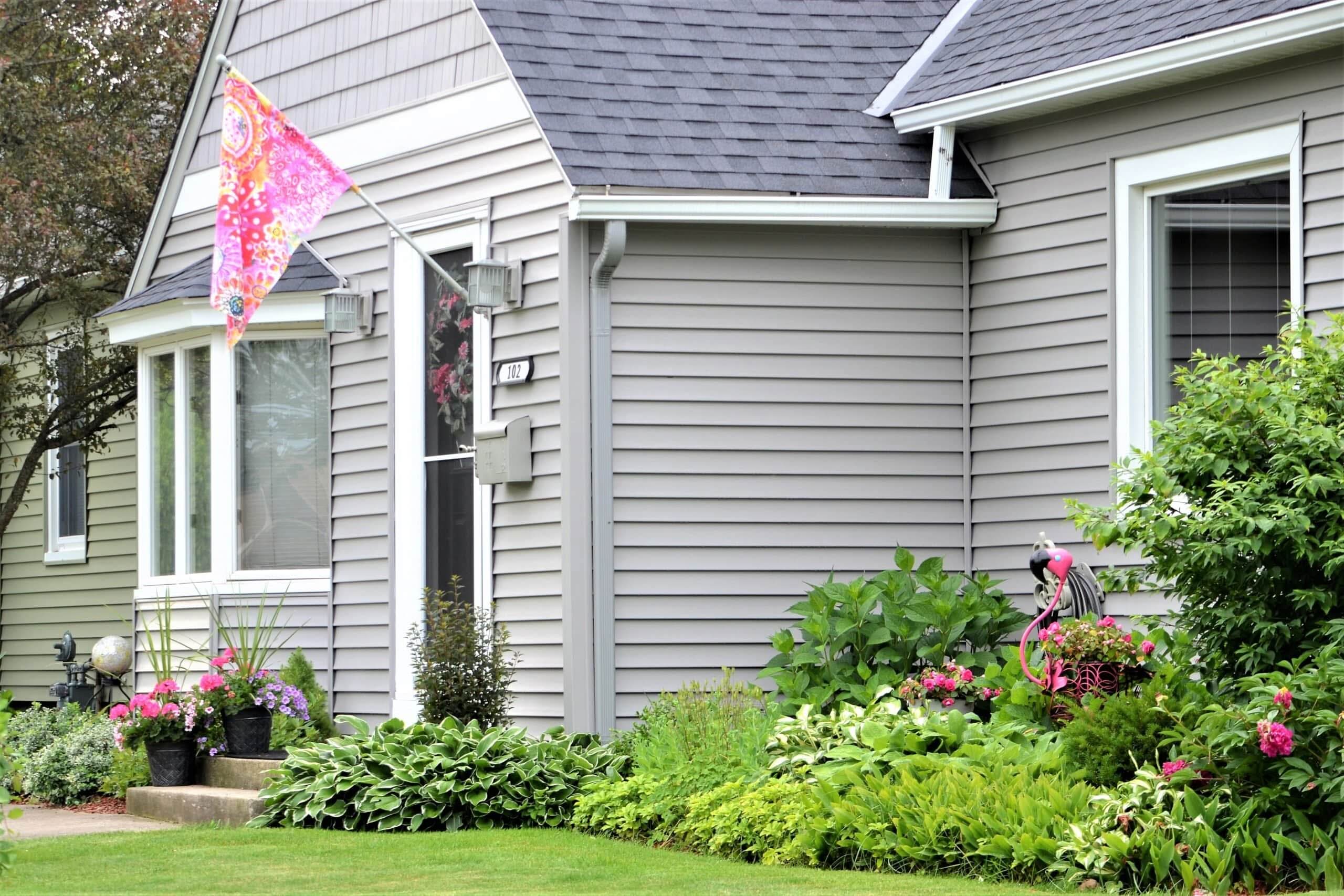 Home with light gray horizontal vinyl siding and white window trim by Always Home Repair